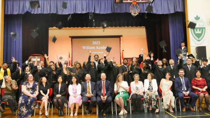 Eine Gruppe von Schülerinnen und Schülern sowie Erwachsenen bei einer Veranstaltung auf dem Campus der William Academy im Jahr 2023.