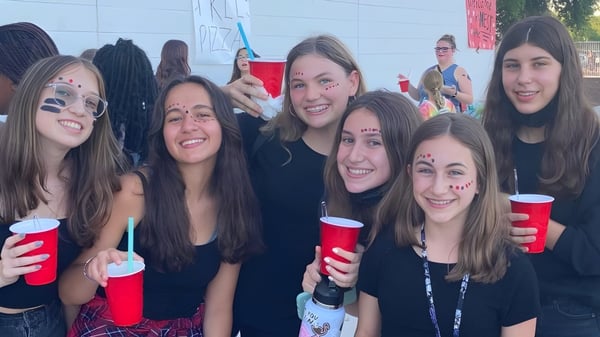 Eine Gruppe junger Frauen der Williams Field High School steht zusammen und hält rote Becher.