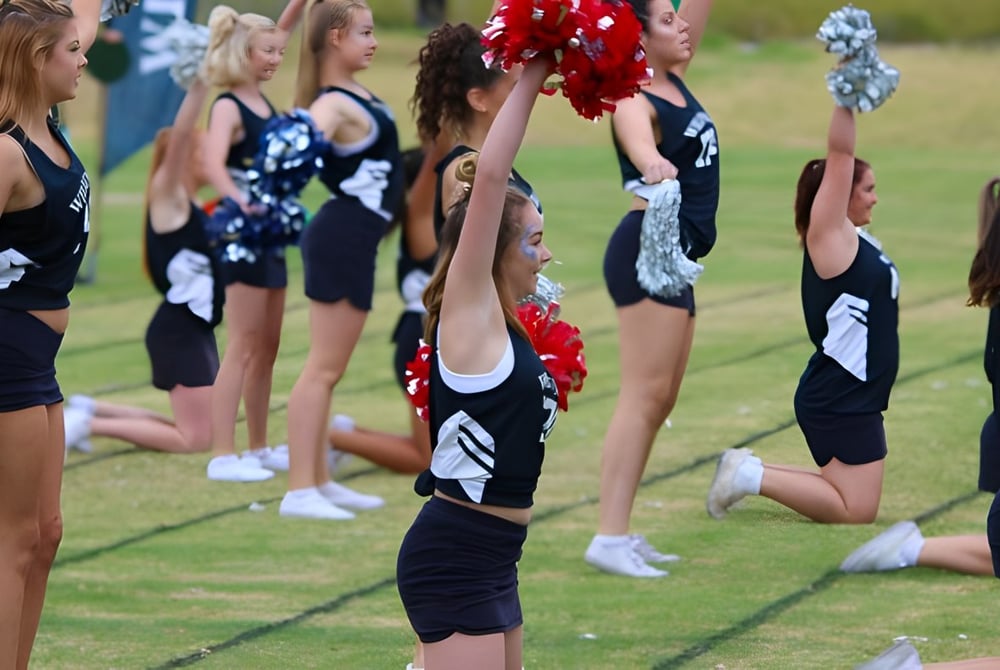 Eine Gruppe Cheerleader führt auf dem Rasenfeld eine synchronisierte Routine an der Willunga High School aus.
