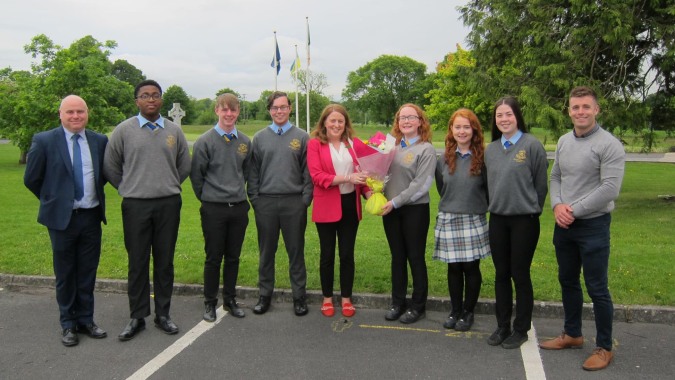 Eine Gruppe von Schülerinnen und Schülern steht gemeinsam im Park auf dem Gelände der Wilson's Hospital School.