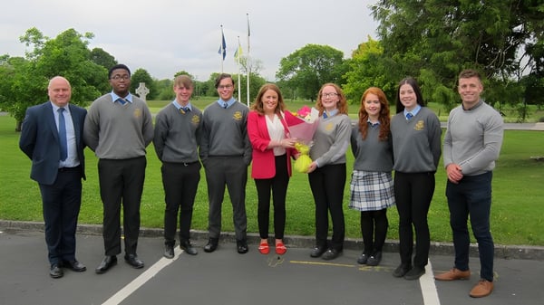 Eine Gruppe von Schülern der Wilson's Hospital School steht in einem Park mit Bäumen und Grünflächen.