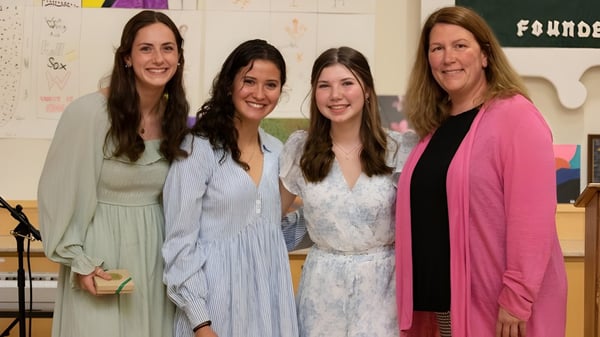 Vier Frauen stehen lächelnd in einem Klassenraum der Winchendon School in Massachusetts.