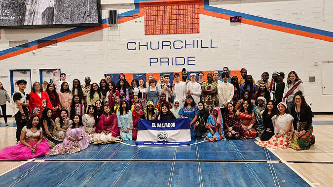 Eine große Gruppe von Schülerinnen und Schülern versammelt sich vor dem Gebäude der Winston Churchill High School zur Pride-Veranstaltung.