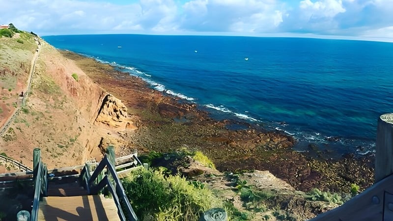 Felsige Küstenlandschaft mit steiler Klippe und weitem blauen Ozean im Hintergrund, nahe der Wirreanda Secondary School.