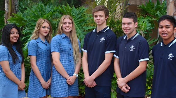 Eine Gruppe Schüler steht im tropischen Außenbereich auf dem Gelände der Wirreanda Secondary School.