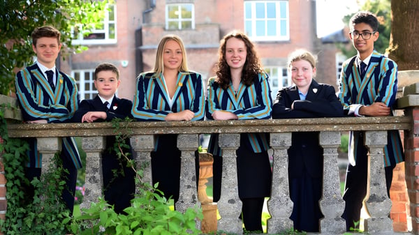 Schüler der Wisbech Grammar School stehen auf einer Holzbrücke umgeben von grüner Vegetation.