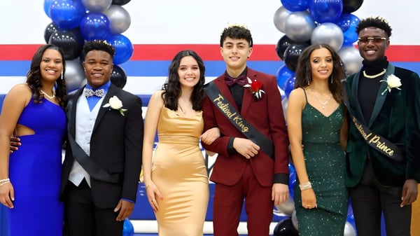 Eine Gruppe von Personen in formeller Kleidung posiert vor blauen und silbernen Luftballons auf dem Gelände der Wisconsin Lutheran High School.