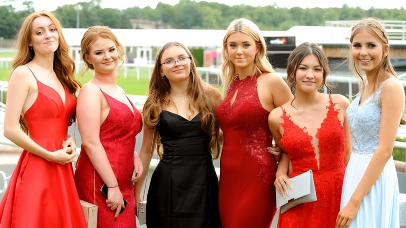 Eine Gruppe Schülerinnen der Woldingham School posiert im Freien vor einem bewaldeten Hintergrund.