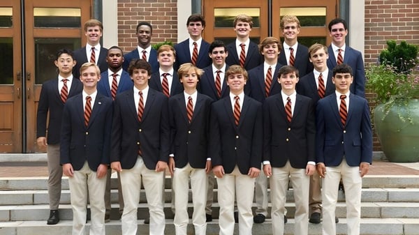 Schüler der Woodberry Forest School stehen auf der Treppe vor einem Backsteingebäude mit einer Holztür.