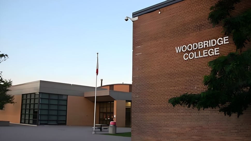 Das Backsteingebäude mit dem Schriftzug Woodbridge College ist von Bäumen und einem gepflasterten Bereich umgeben.
