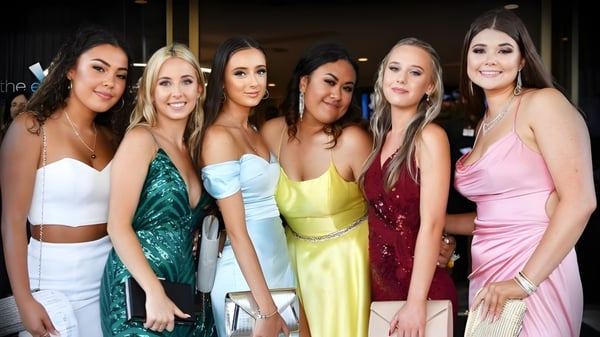 Eine Gruppe Schülerinnen des Woodcrest State College posiert zusammen bei einer formellen Veranstaltung.