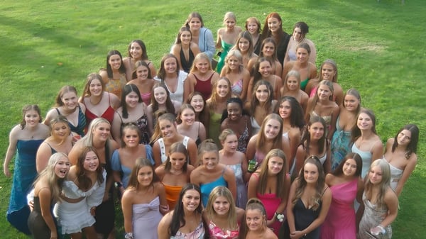 Eine Gruppe junger Frauen der Woodford House steht gemeinsam auf einer Wiese und posiert für ein Gruppenfoto.
