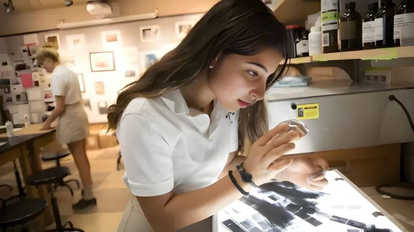 Eine Schülerin der Woodward Academy steht mit einem Tablet in einem Café und konzentriert sich auf das Gerät.