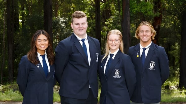 Vier Schülerinnen und Schüler der Woolgoolga High School stehen zusammen in einem bewaldeten Bereich.