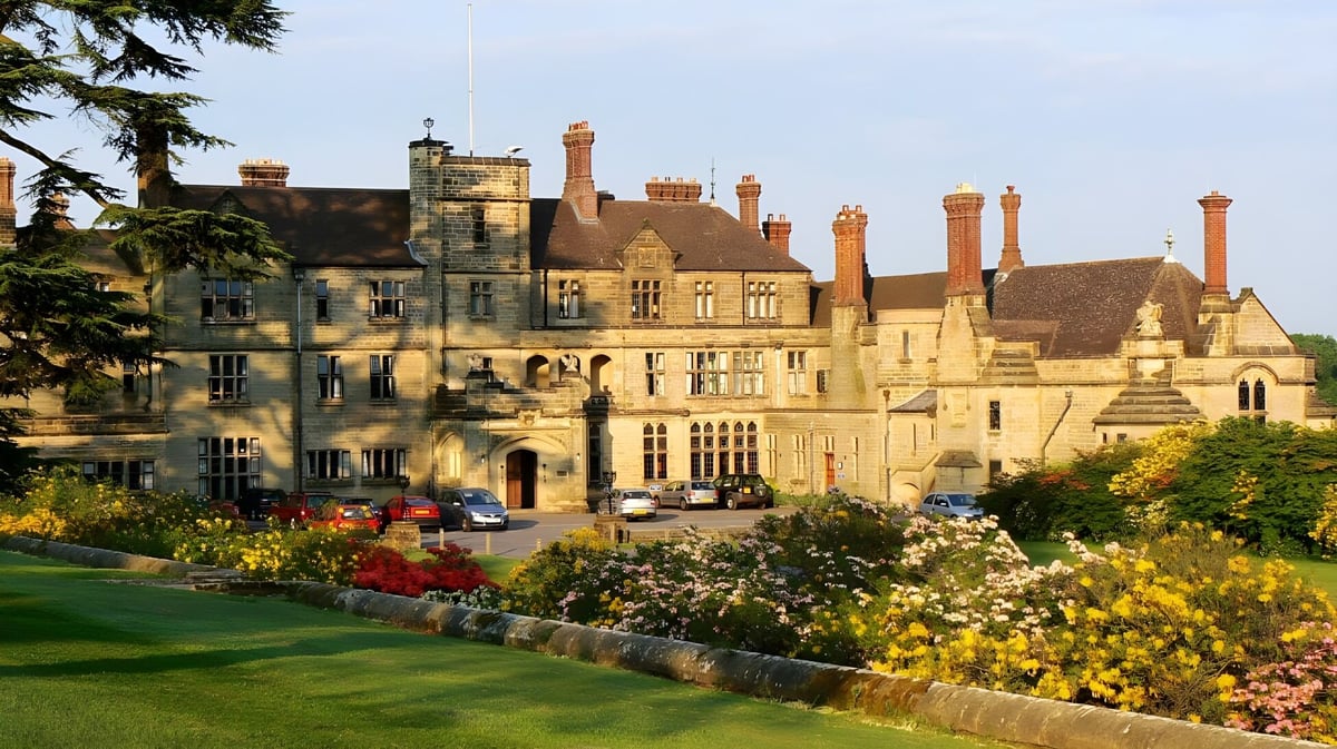 Das historische Schlossgebäude der Worth School ist umgeben von gepflegten Gärten und einer grünen Rasenfläche.
