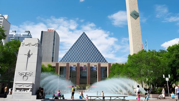 Blick auf die moderne Skyline mit spezieller Architektur und Menschen am Brunnen vor der W.P. Wagner High School.