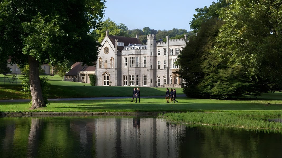 Das gotische Schloss der Wycombe Abbey School spiegelt sich in einem Teich auf dem weitläufigen Schulgelände.