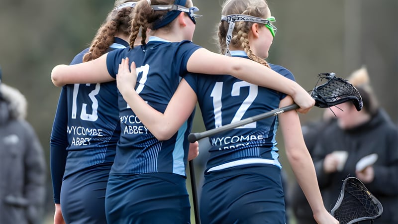 Zwei junge Sportlerinnen umarmen sich auf dem Sportfeld der Wycombe Abbey School.
