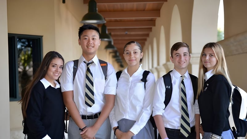 Eine Gruppe Schülerinnen und Schüler steht in einem Flur mit Holzdecken auf dem Campus der Xavier College Preparatory High School.