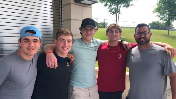 Fünf Schülerinnen und Schüler stehen im Außenbereich vor einem Gebäude auf dem Campus der Xavier High School.