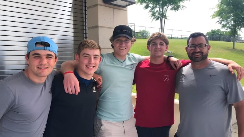 Fünf Schülerinnen und Schüler stehen im Außenbereich vor einem Gebäude auf dem Campus der Xavier High School.