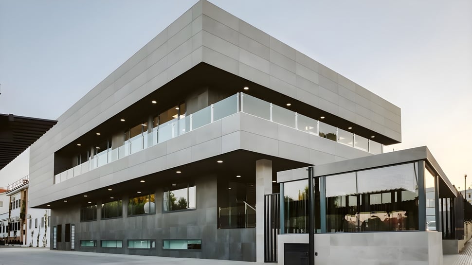 Das moderne, mehrstöckige Gebäude mit großen Glasfenstern auf dem Campus der Yago School.