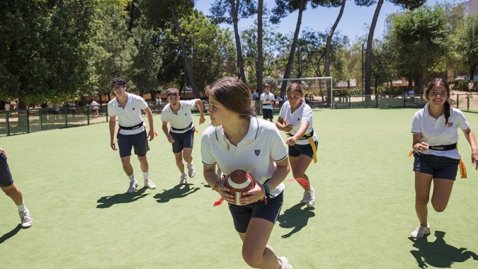 Eine Gruppe Schüler auf dem Sportplatz der Yago School bei sportlichen Aktivitäten im Freien.