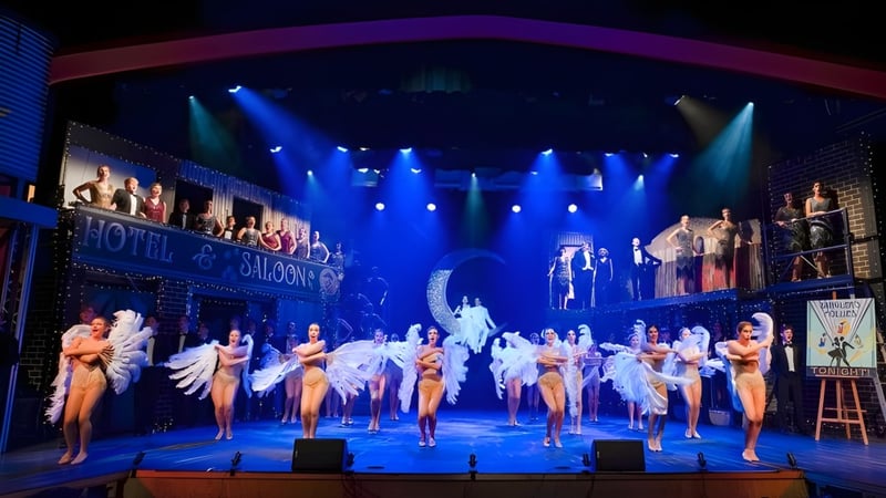 Schülerinnen und Schüler der Yeronga State High School führen eine Tanzaufführung auf einer farbenfrohen Bühne mit Theaterkulisse auf.