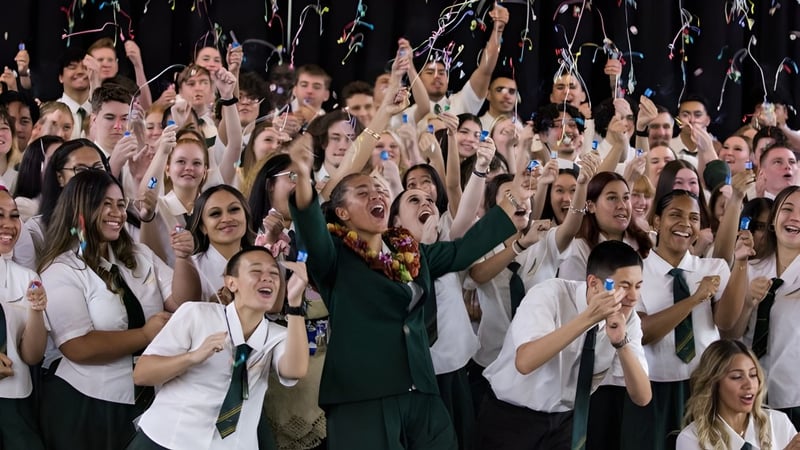 Schülerinnen und Schüler der Yeronga State High School feiern gemeinsam mit erhobenen Armen bei einer Veranstaltung.