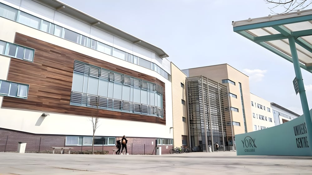 Das moderne mehrstöckige Gebäude des York College mit einer Person, die über die offene Plaza geht.