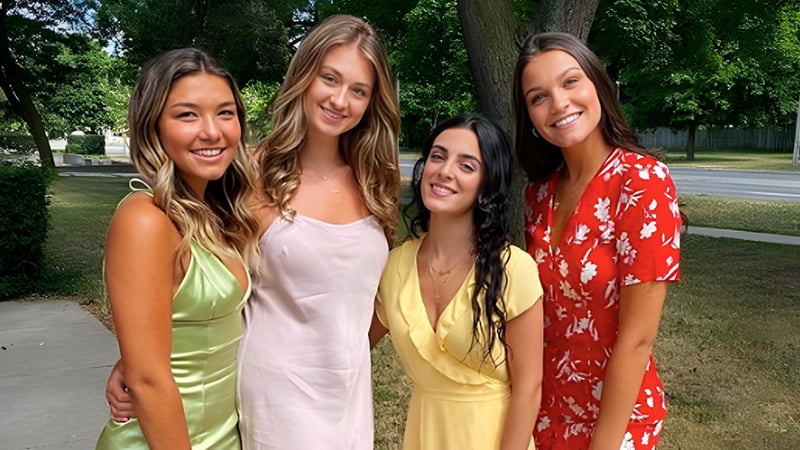 Vier Schülerinnen stehen gemeinsam in einem Park auf dem Gelände des York Mills Collegiate Institute.