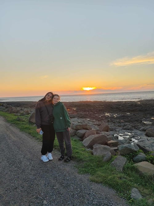 Zwei Mädchen vor einem Sonnenuntergang auf dem Meer