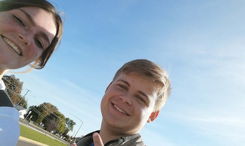 Ein Mädchen und ein Junge lächeln in die Kamera