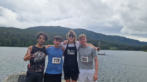 Vier Jungs vor einem See und Bergen im Hintergrund