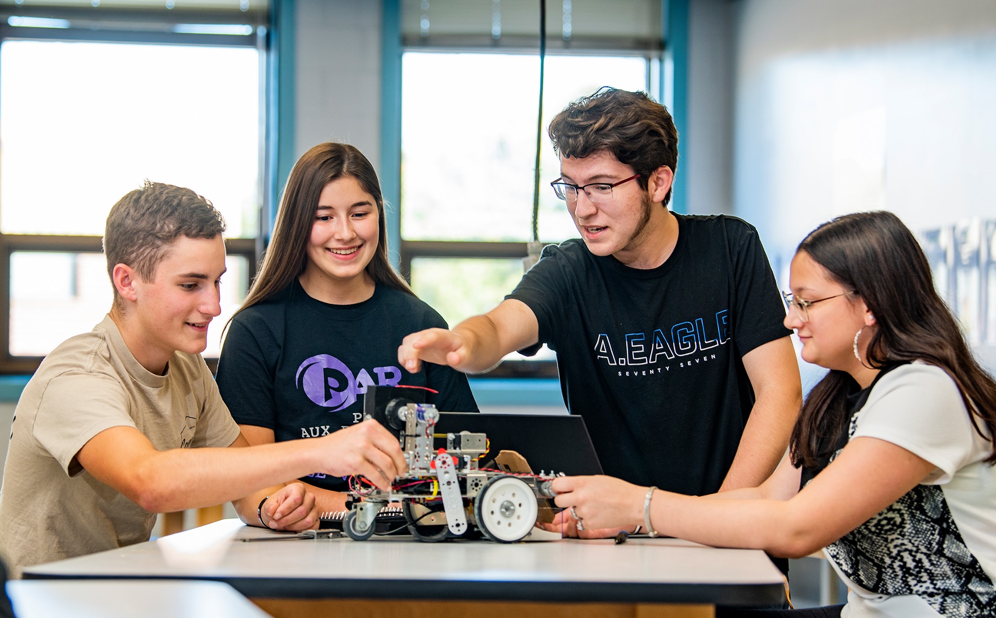 Eine Gruppe von Schüler:innen sitzen gemeinsam an einem Projekt