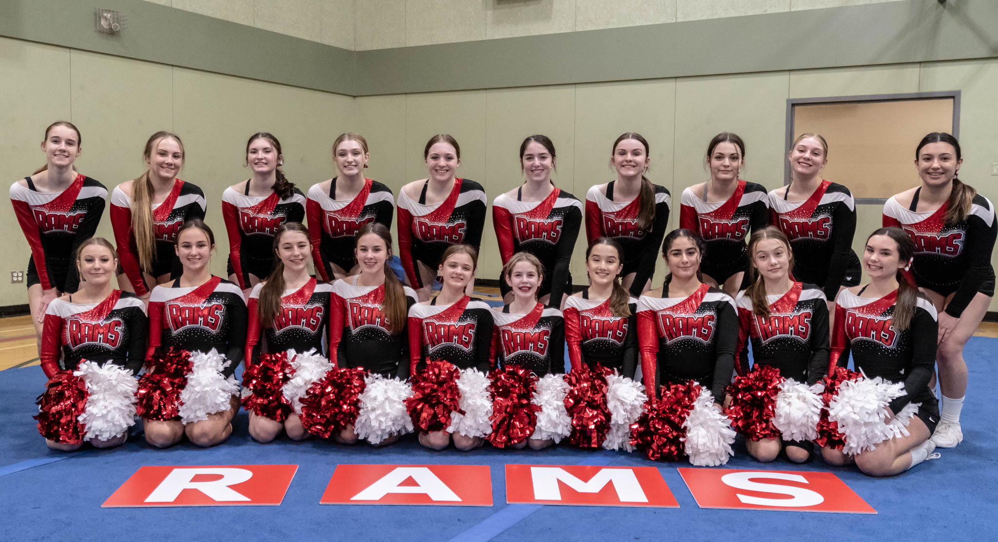 Eine Gruppe von Cheerleaderinnen in einer Turnhalle in Uniform