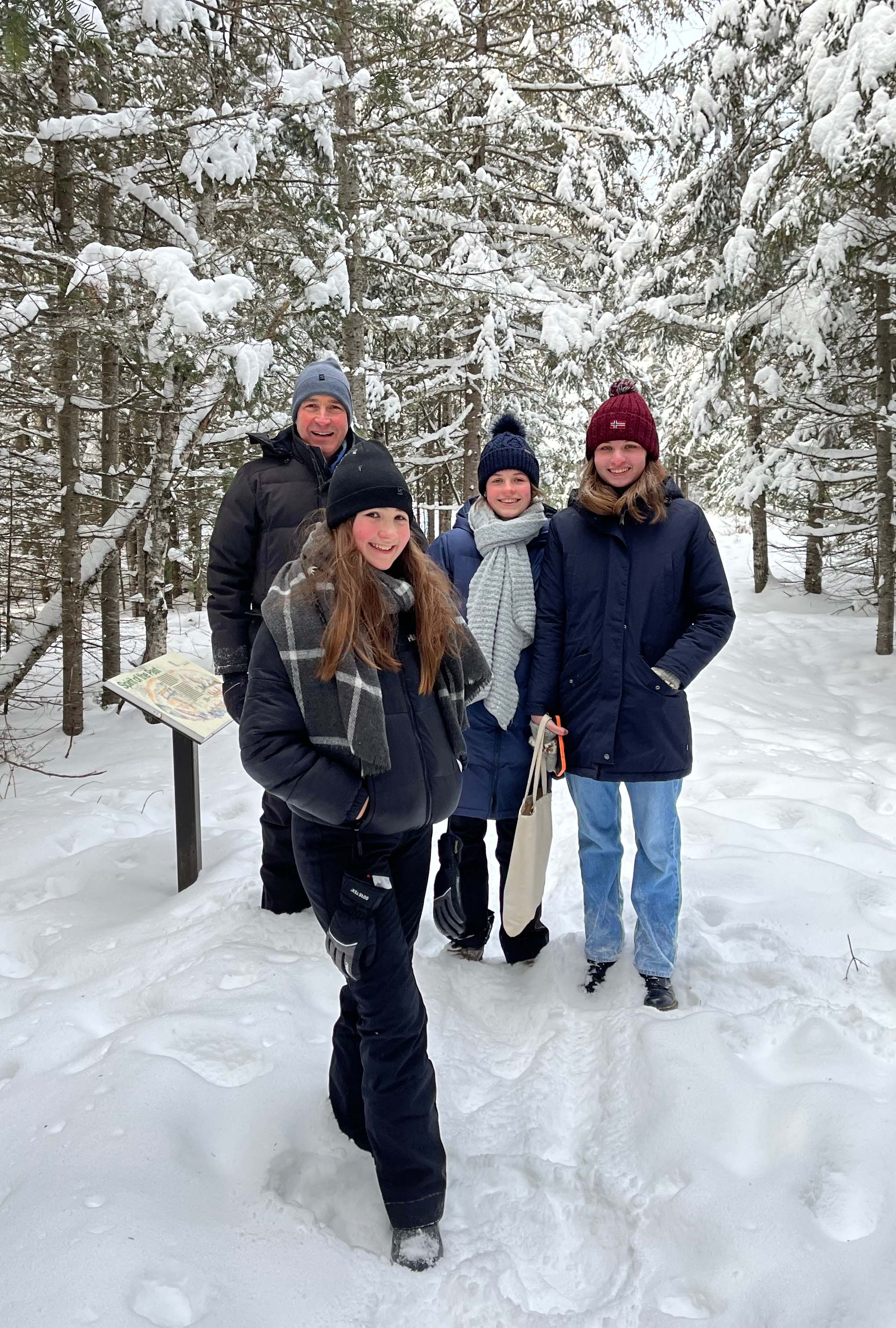 Eine Teilnehmerin mit ihrer Gastfamilie im Schnee