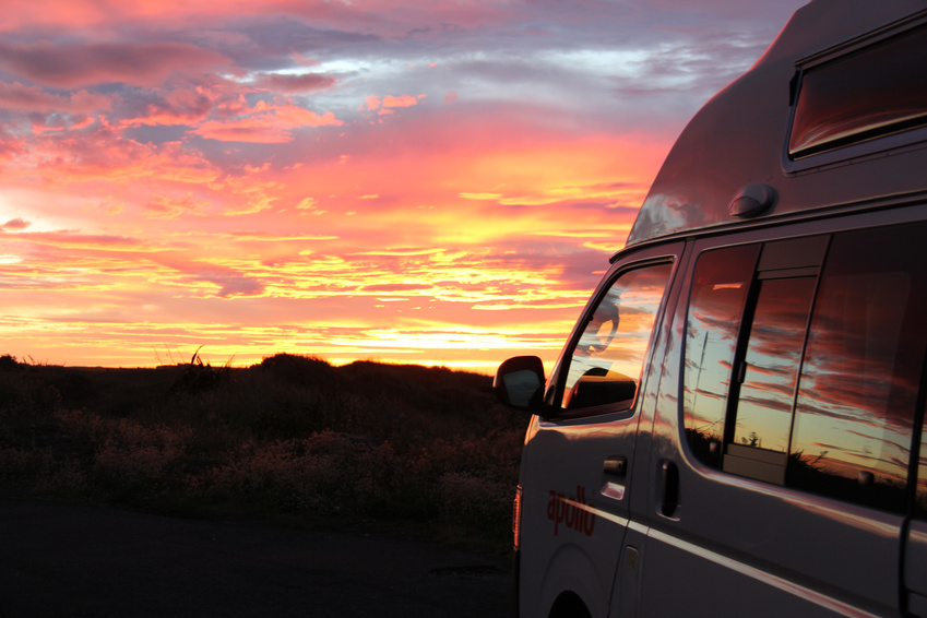 Ein Camper Van steht im Sonnenuntergang
