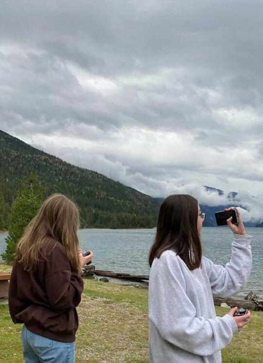 2 Freundinnen machen Fotos vom Meer