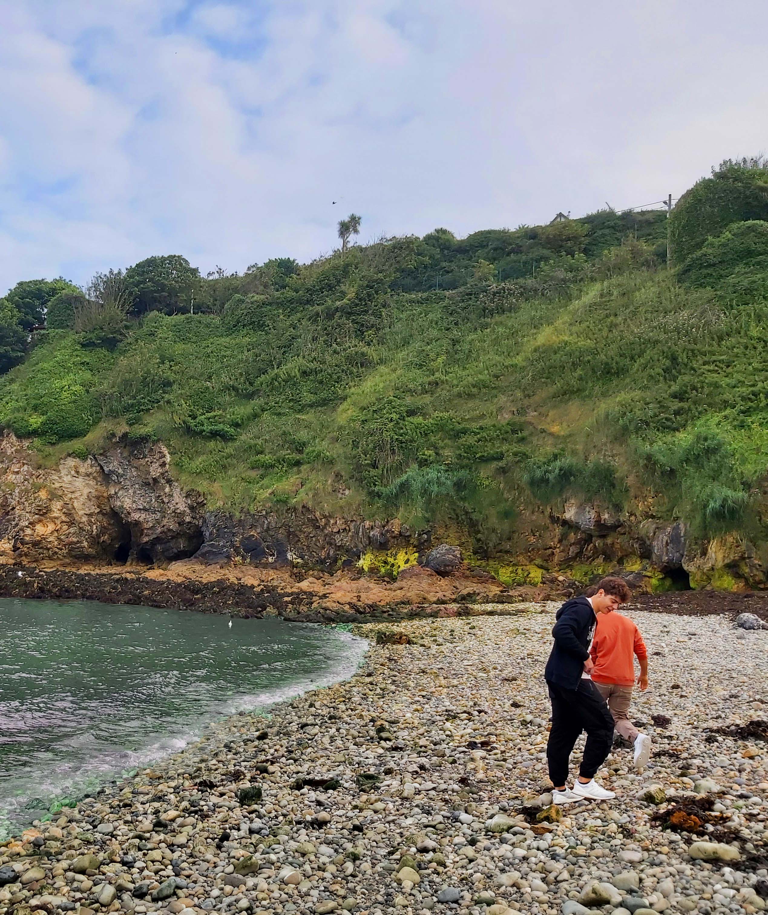Zwei Teilnehmer laufen am Steinstrand in Irland entlang