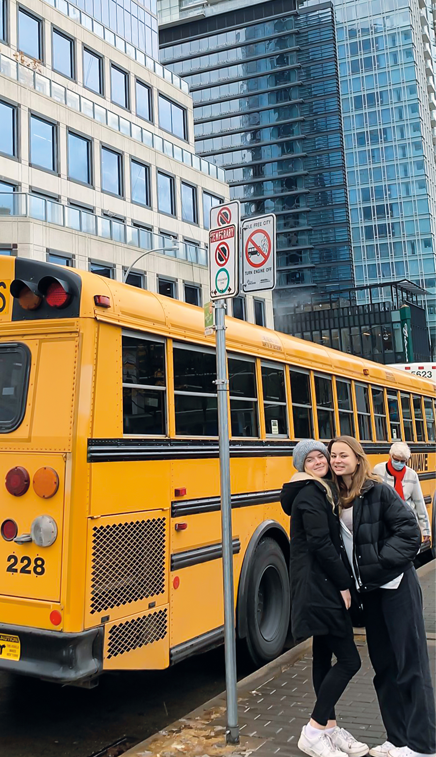 Zwei Teilnehmerinnen stehen in Kanada vor einem gelben Schulbus